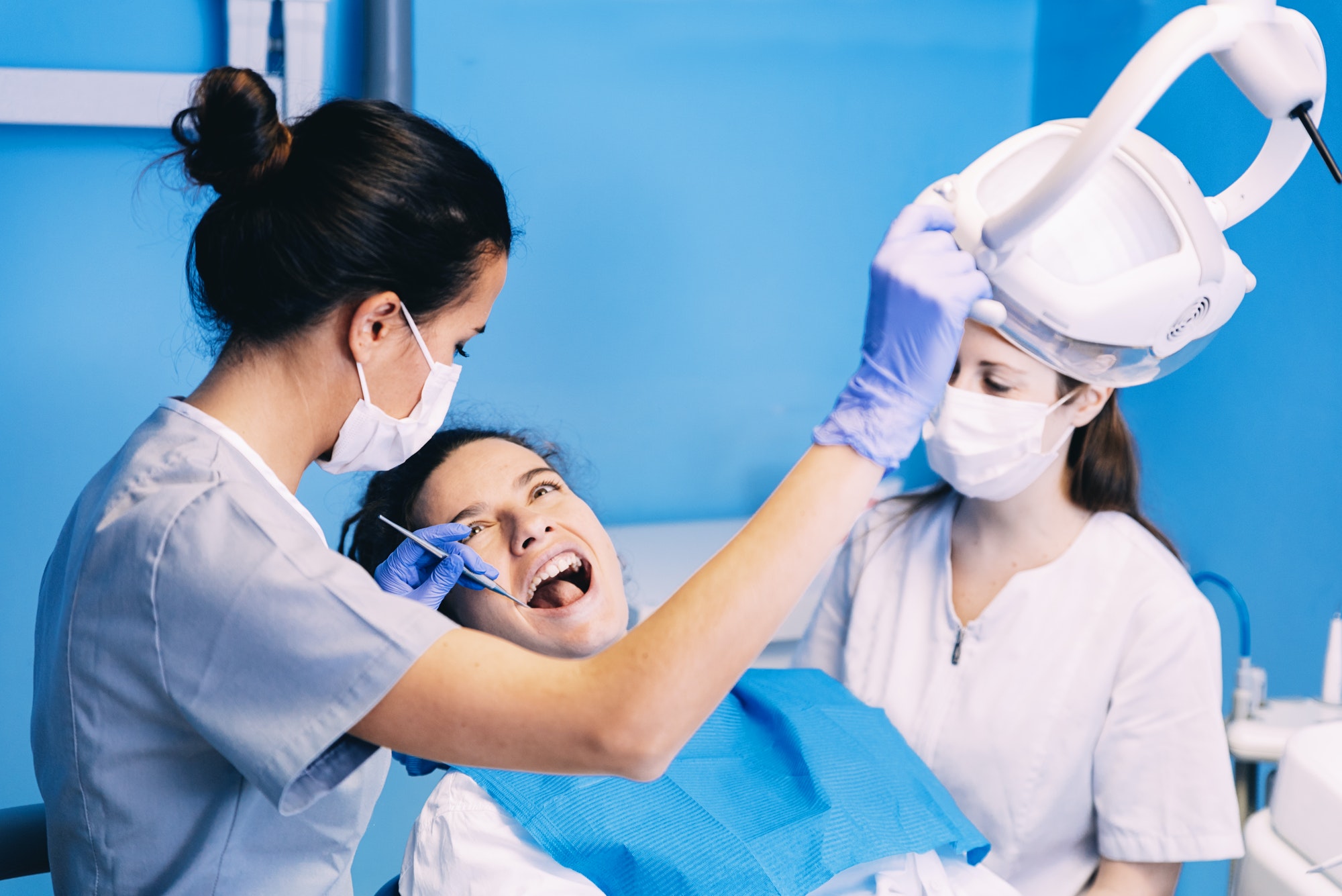 Dentist repairing a patient's broken tooth in a treatment room