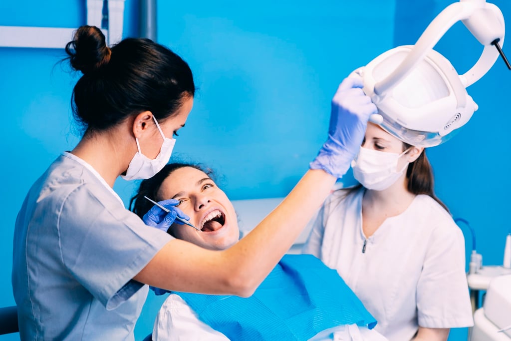 Dentist repairing a patient's broken tooth in a treatment room