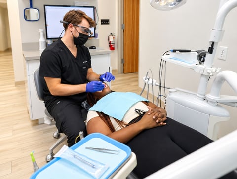 Aroma Dental dentist treating a patient in a modern treatment room