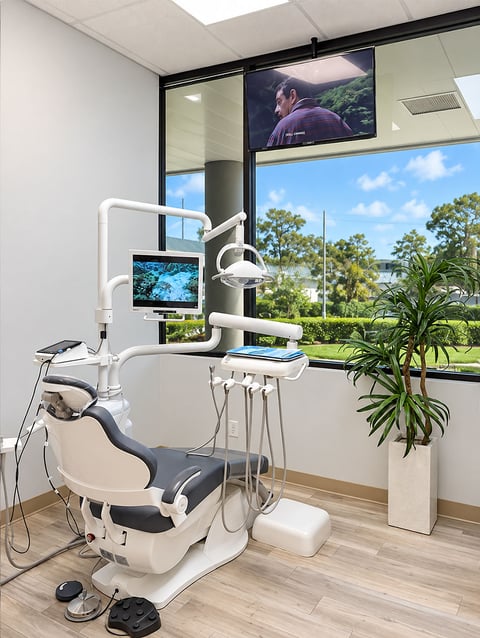 Aroma Dental treatment room with dental chair, monitor and garden view