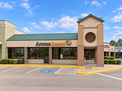 Exterior of the Aroma Dental clinic building with branded signage