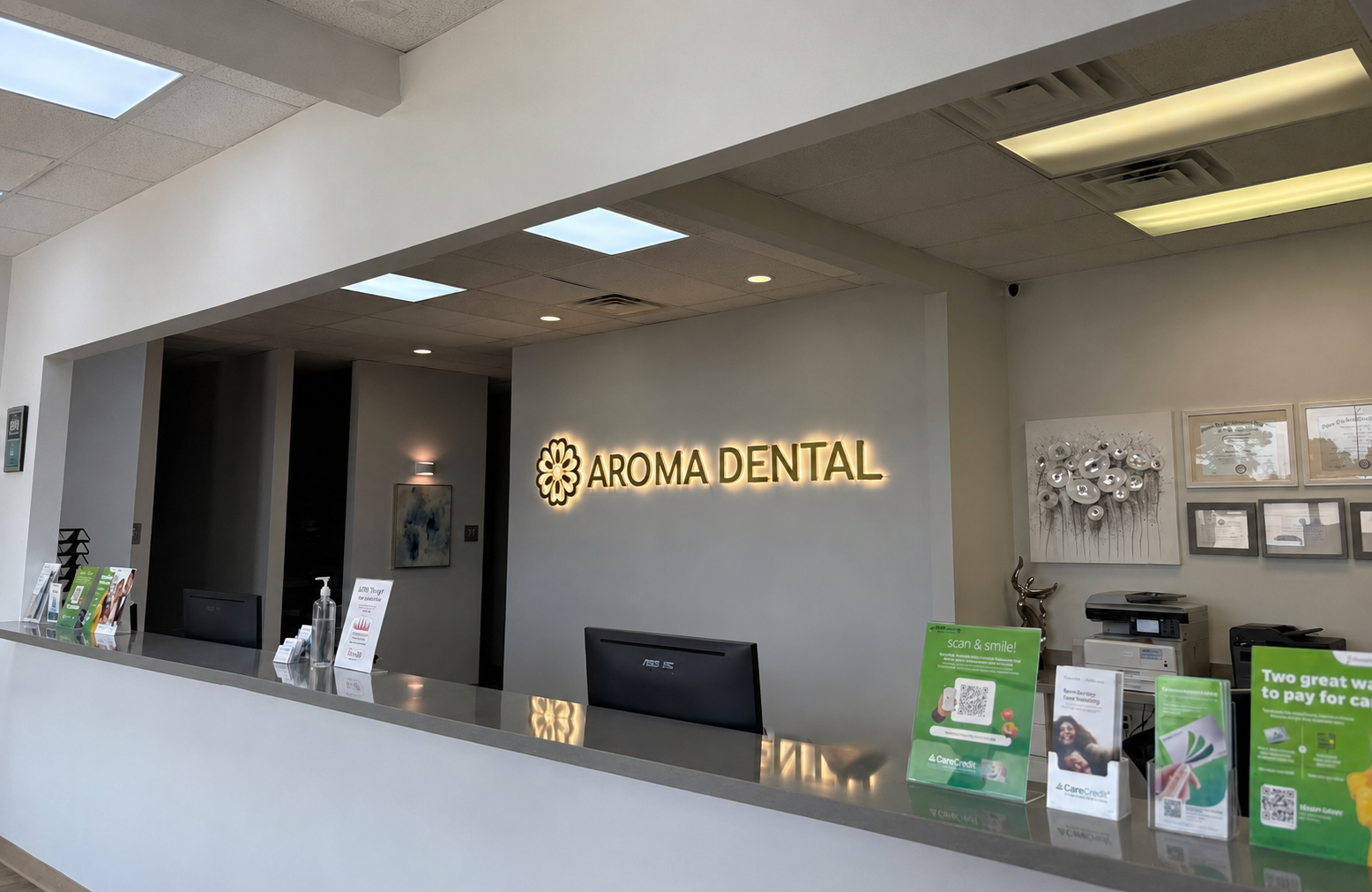 Aroma Dental front desk with illuminated lobby signage