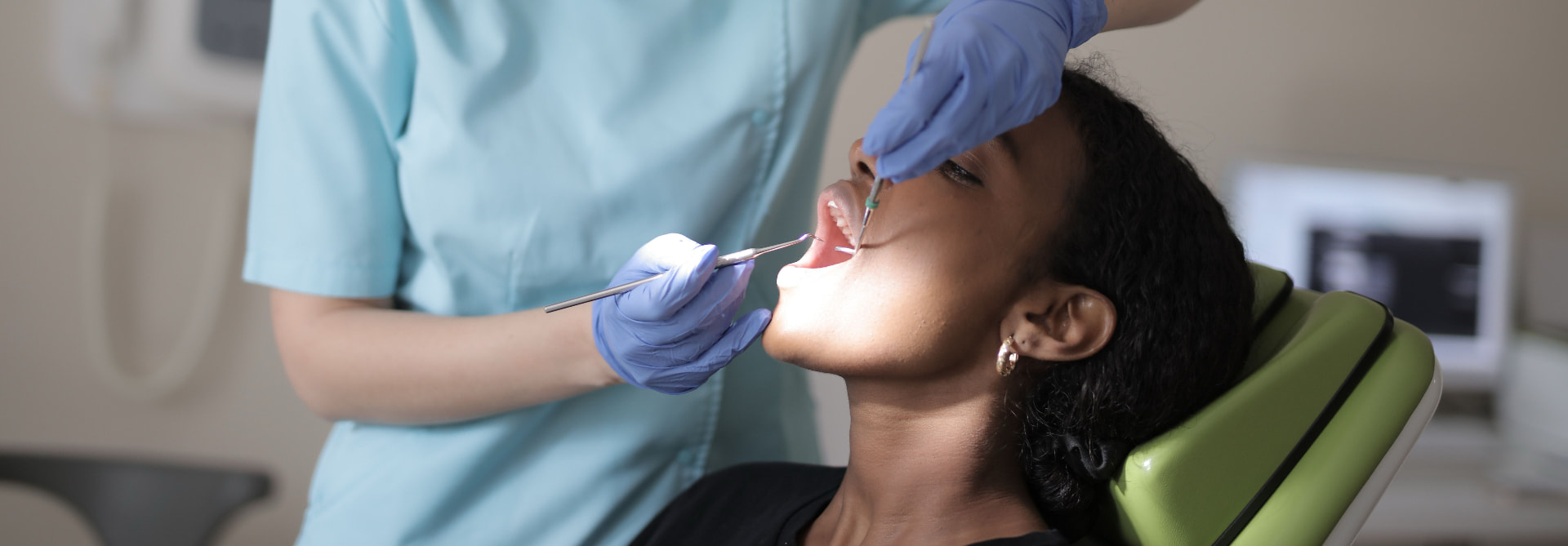 Dental Hygiene at Aroma Dental in Humble, TX: a dental hygienist coaching a patient on brushing and flossing technique at the chair