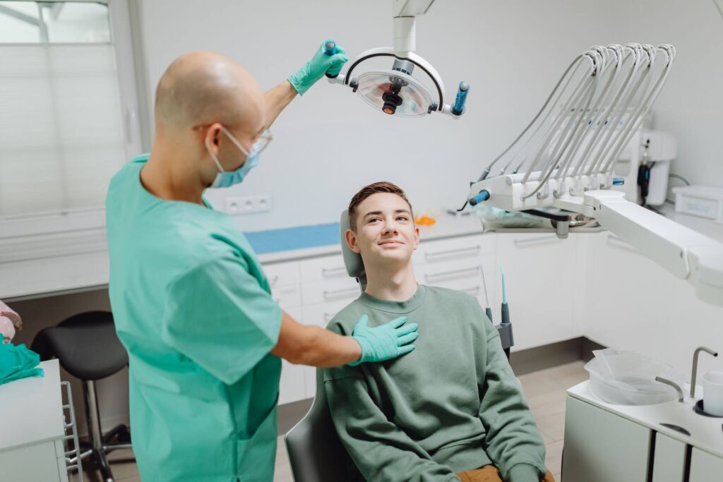 Dentist examining a patient under dental light in a modern clinic setting.
